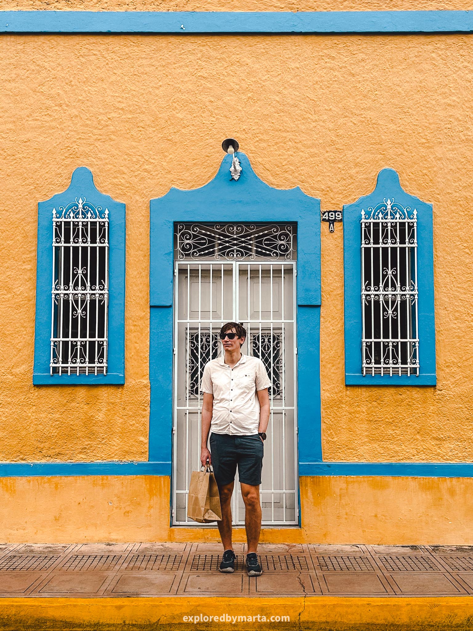 Merida, Mexico-photo perfect colorful houses and a yellow church with two spires in Parque de Santa Ana in Merida, Mexico