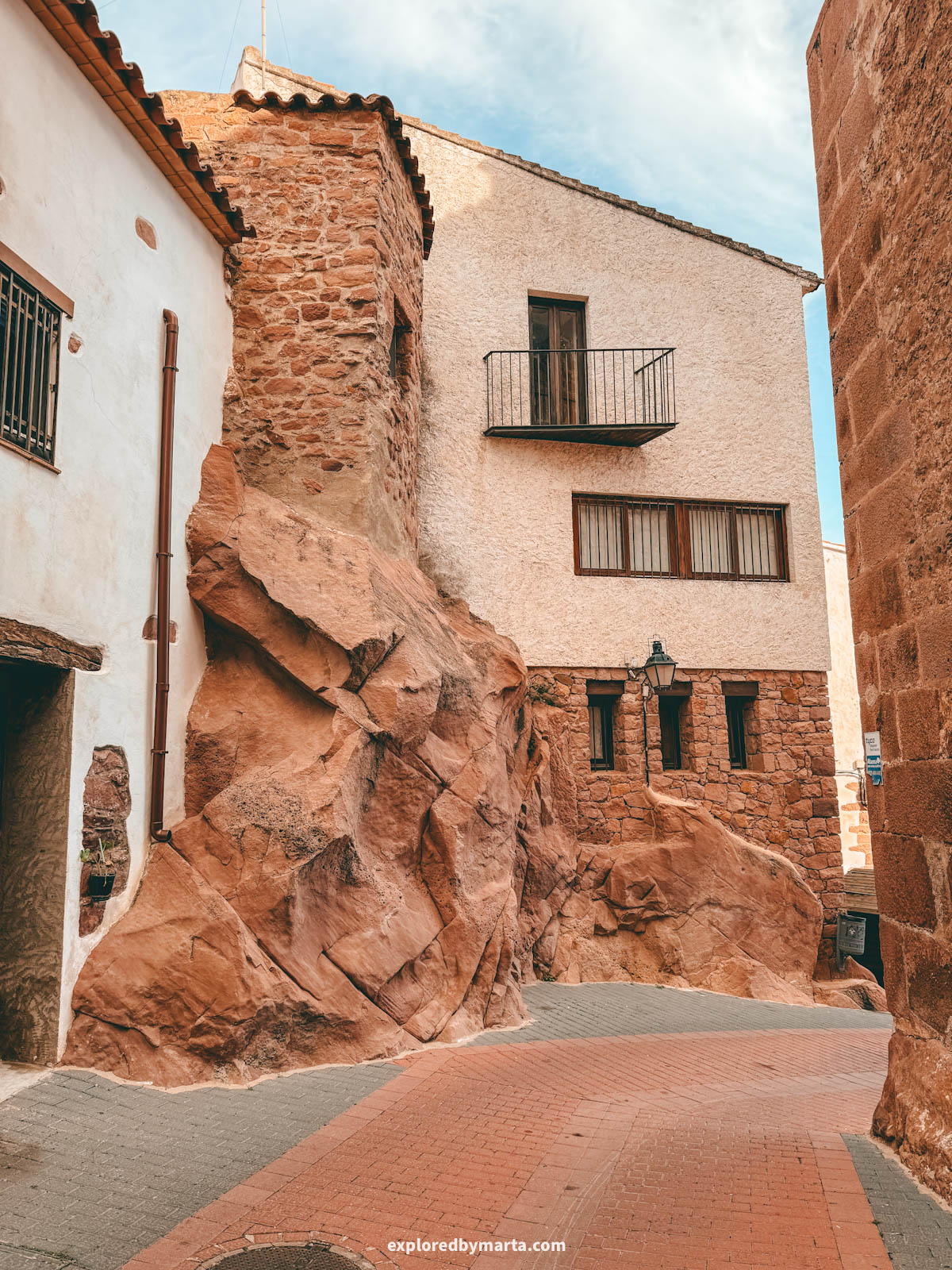 Historical houses integrated into red rock walls in the old town of Vilafamés, Valencia Region, Spain