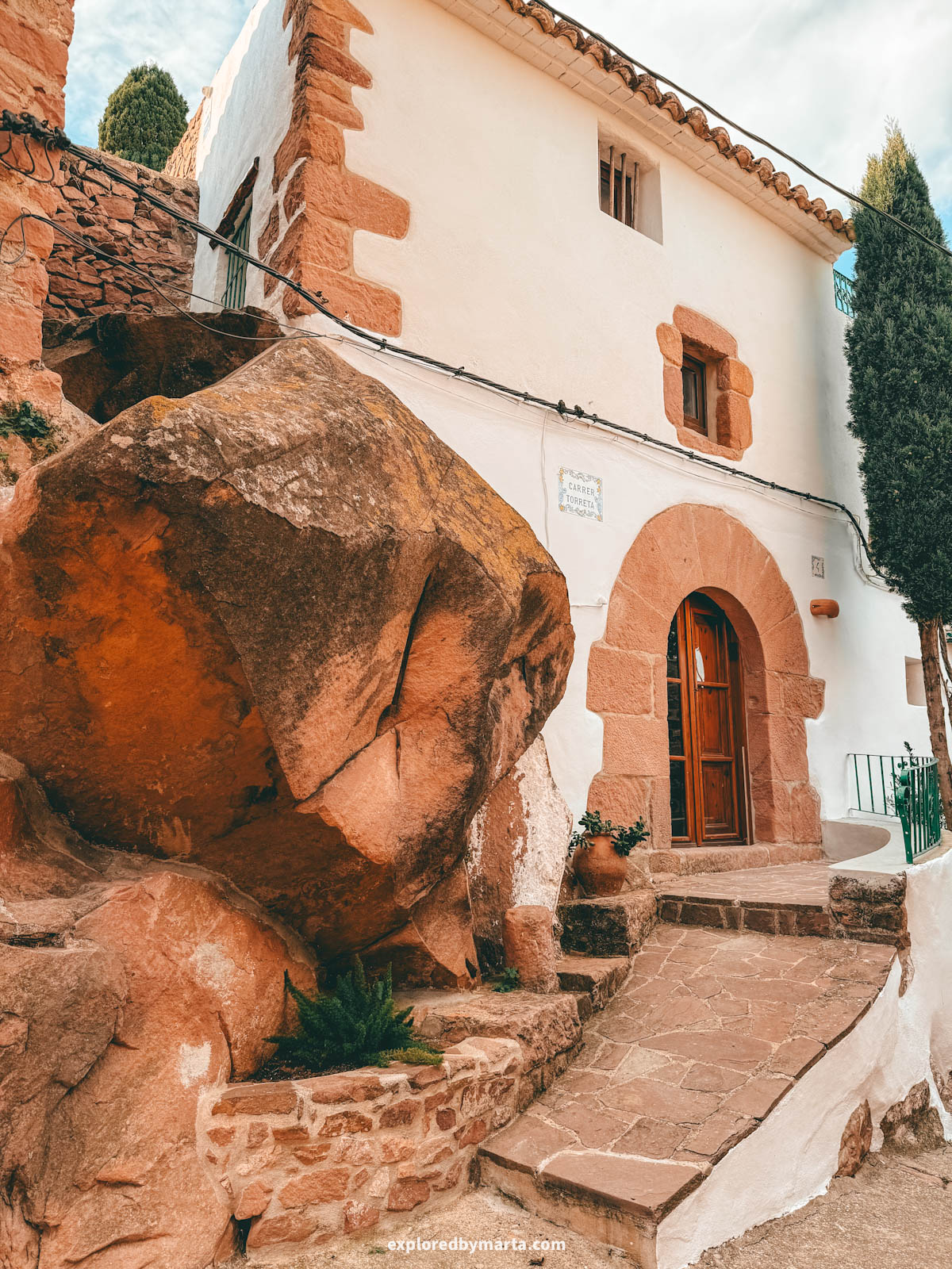 Historical houses integrated into red rock walls in the old town of Vilafamés, Valencia Region, Spain