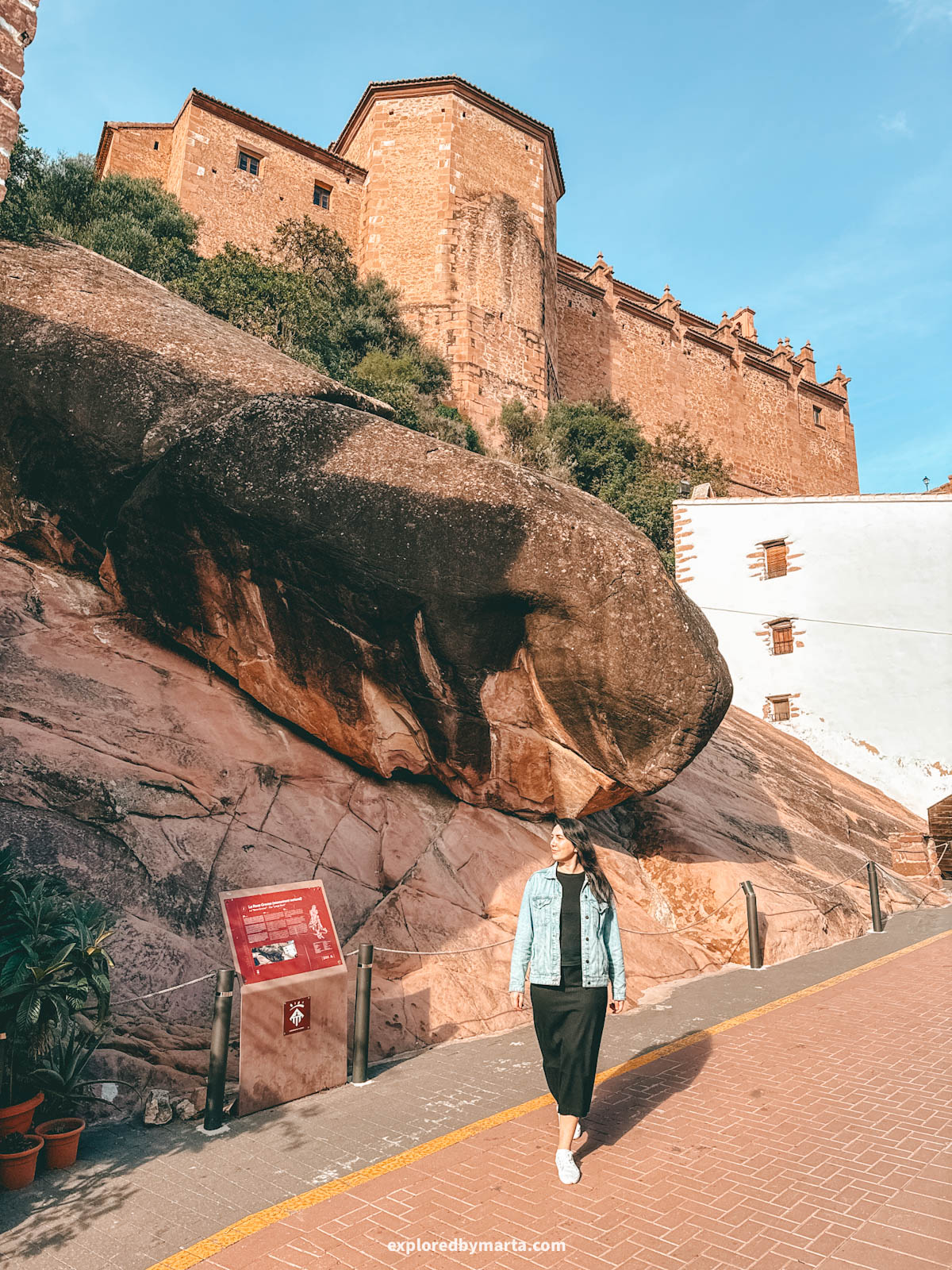 La Roca Grossa in Vilafamés, a massive overhanging rock formation beneath a historic stone building in Vilafamés, Valencia Region, Spain