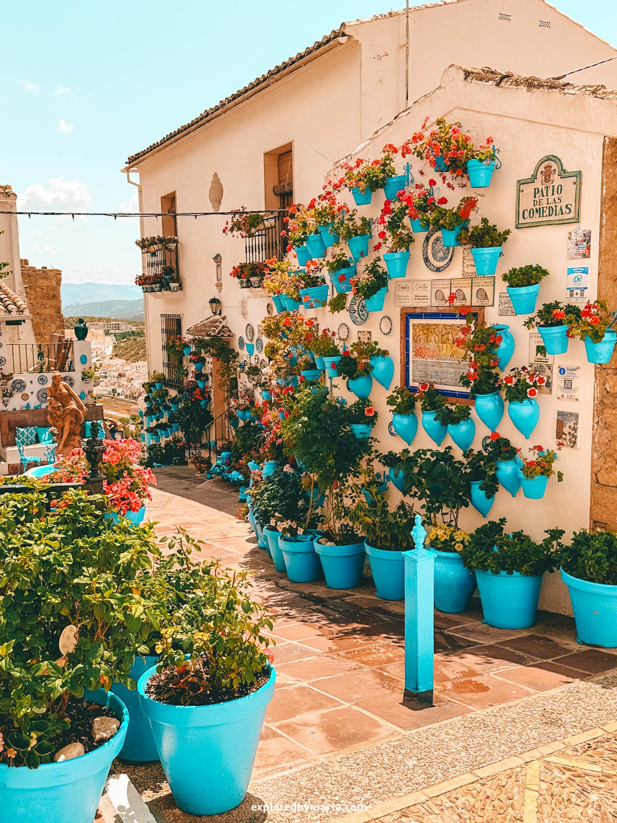 Patio de las Comedias flower courtyard with blue flower pots in Iznajar village in Cordoba Province, Southern Spain