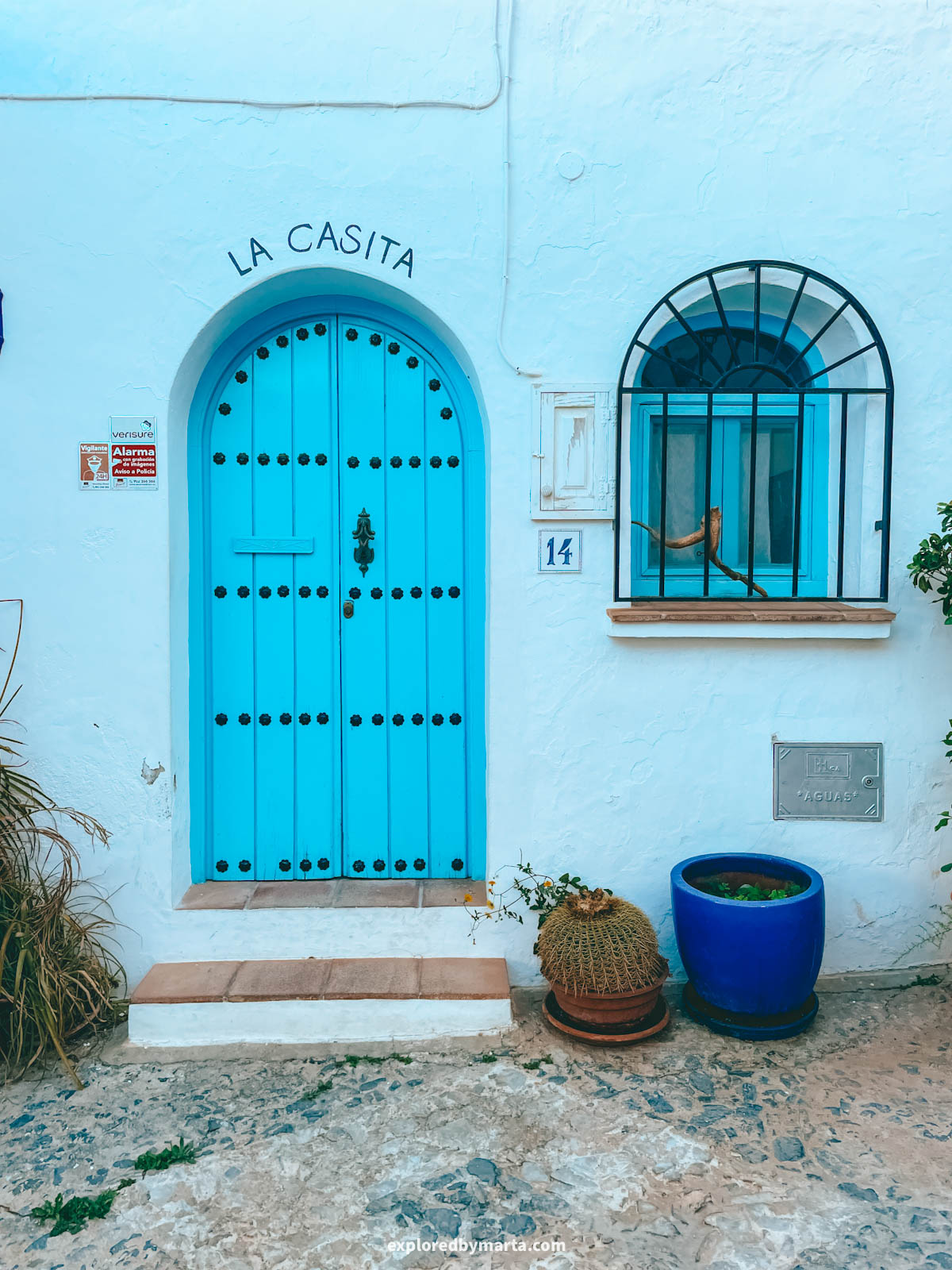 The blue La Casita doors with the arched window in Frigiliana, Spain
