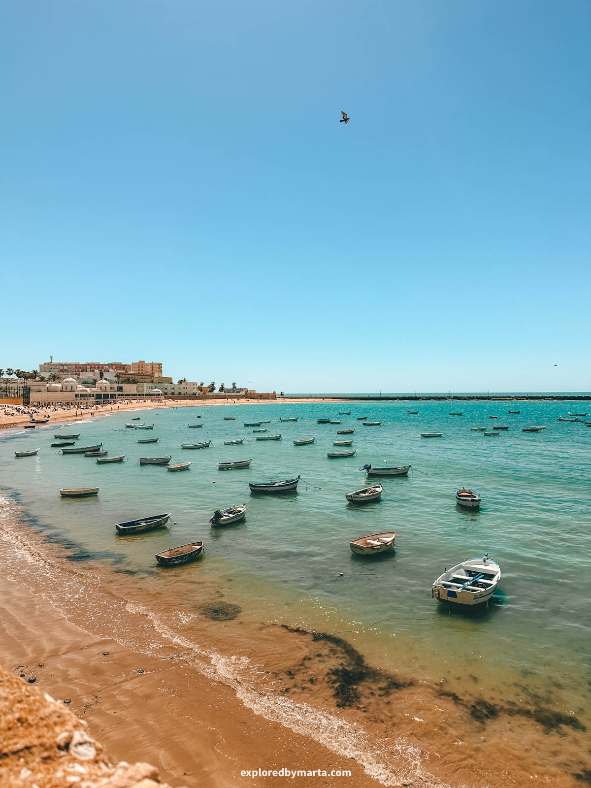 Fishing boats floating next to La Caleta Beach in Cádiz, Spain
