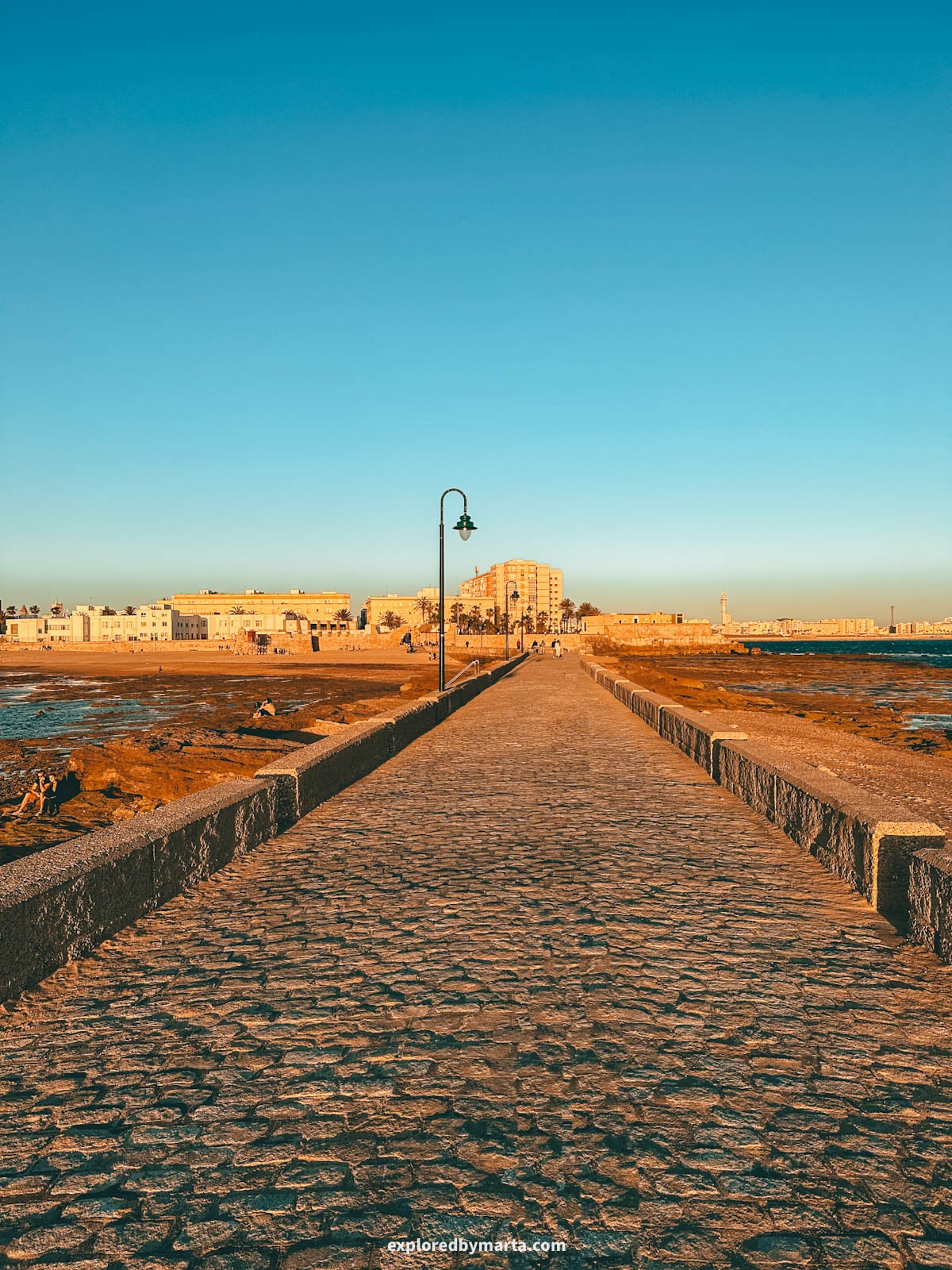 Stone causeway connects Castillo de San Sebastián and Cádiz