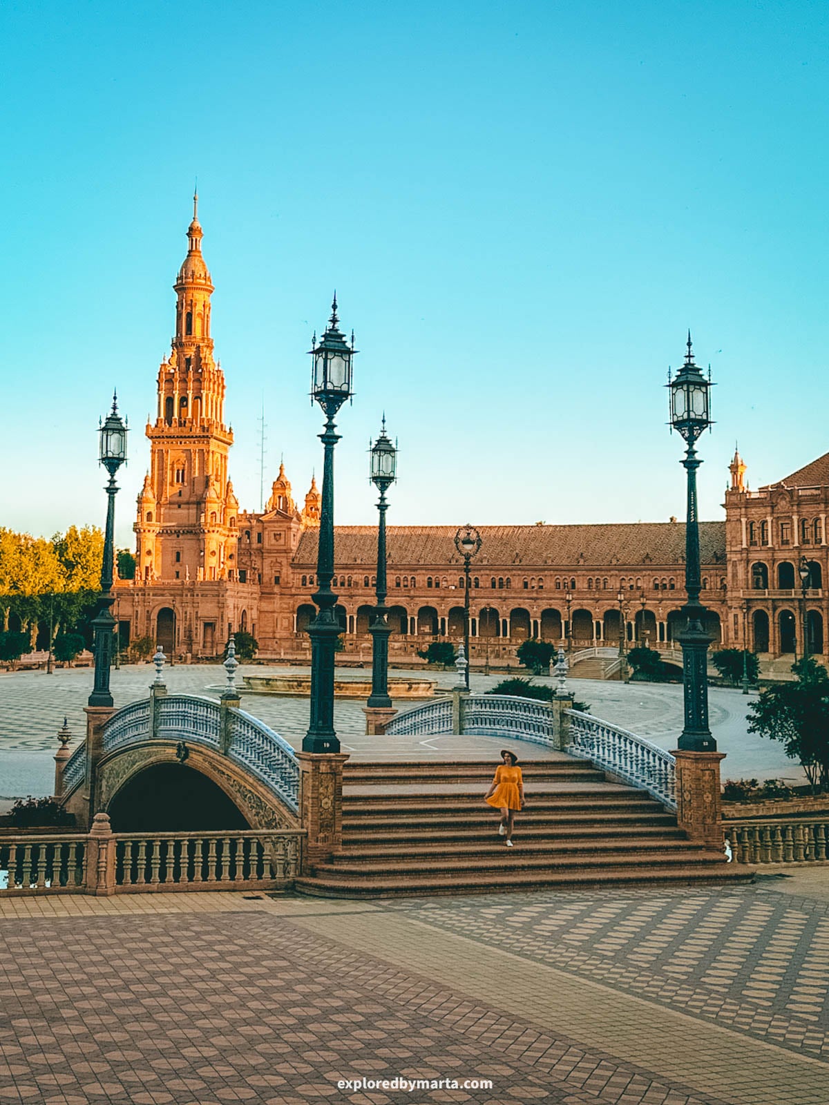 Walking over one of the tiled bridges at Plaza de España in Seville Spain