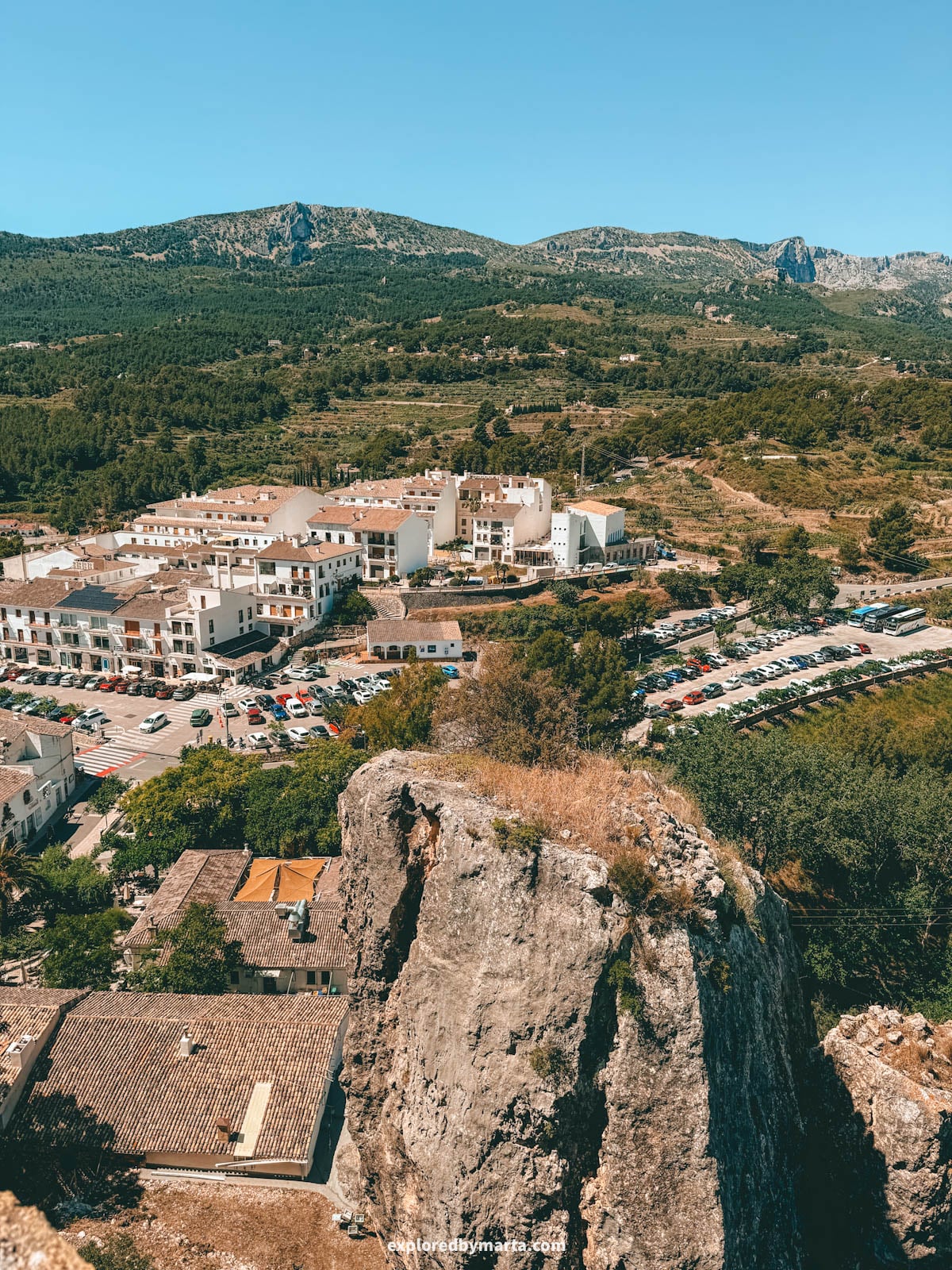 Looking down over the modern part of Guadalest and the mountains from the cemetery viewpoint in Guadalest, Spain