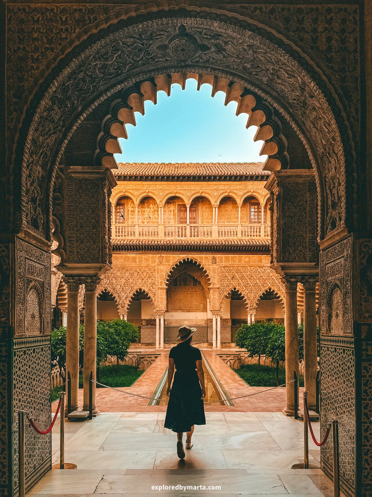 The Patio de las Doncellas with its reflecting pool and Mudéjar arches at the Royal Alcázar of Seville, Spain