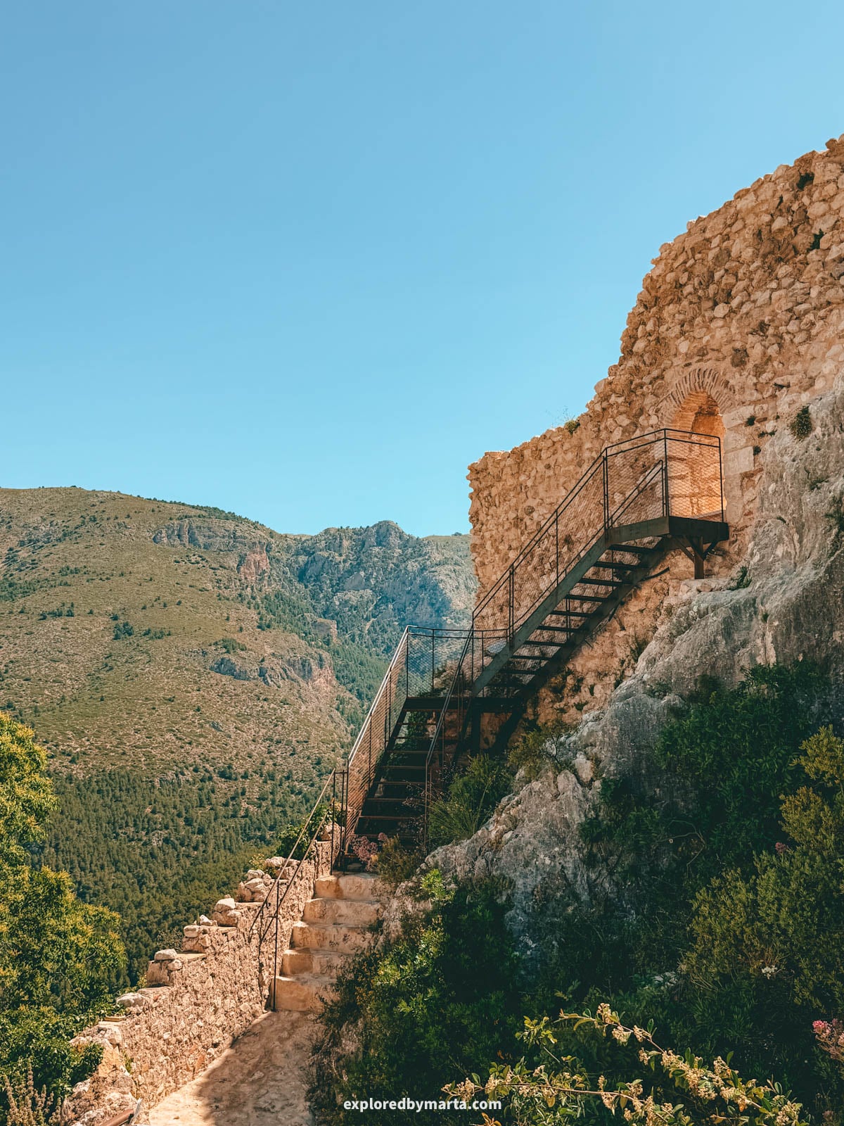 The ruins of Castell de la Alcozaiba on the rock seen from Mirador del Calvari in Guadalest, Spain