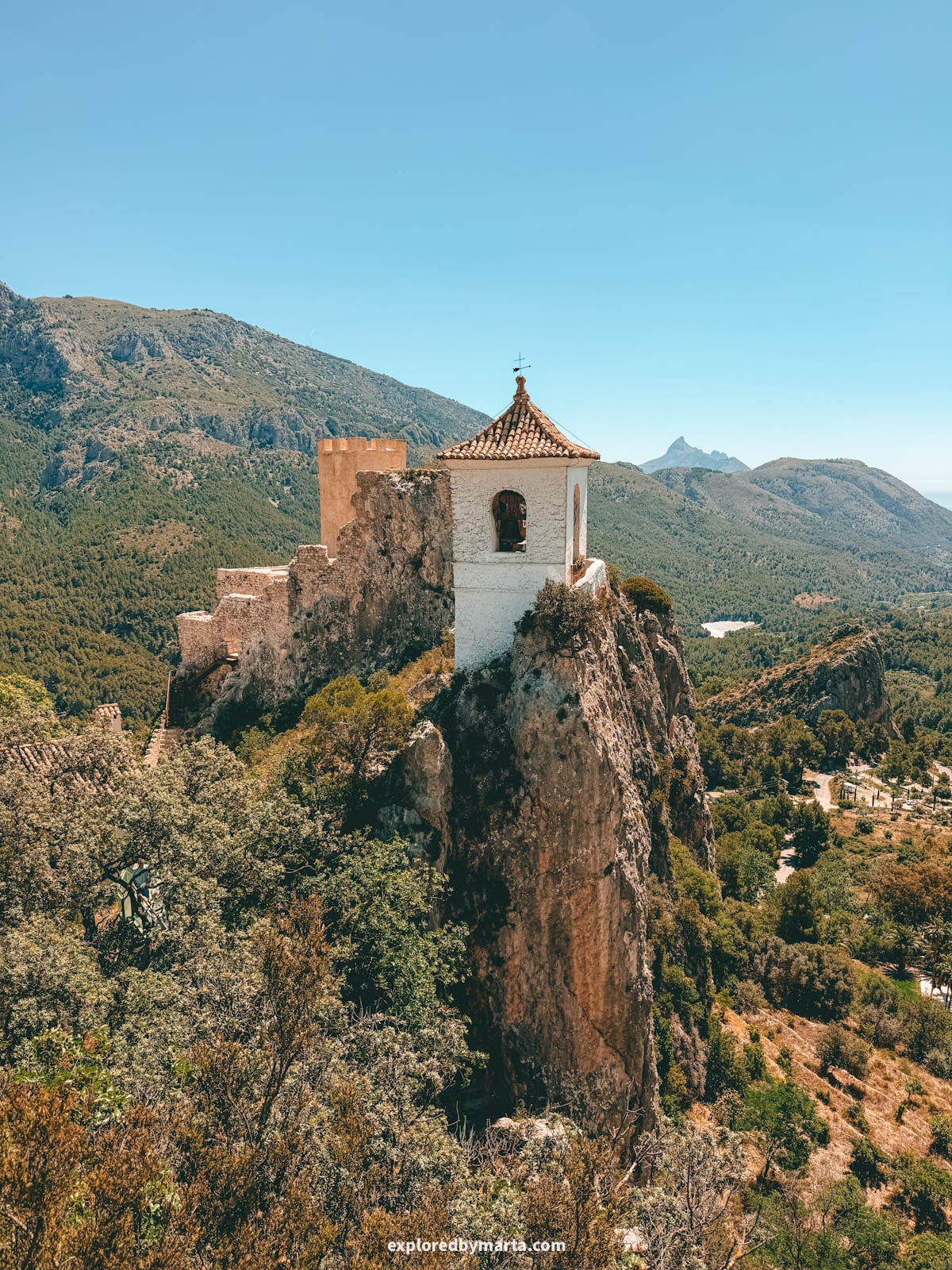 The ruins of Castell de la Alcozaiba on the rock seen from Mirador del Calvari in Guadalest, Spain