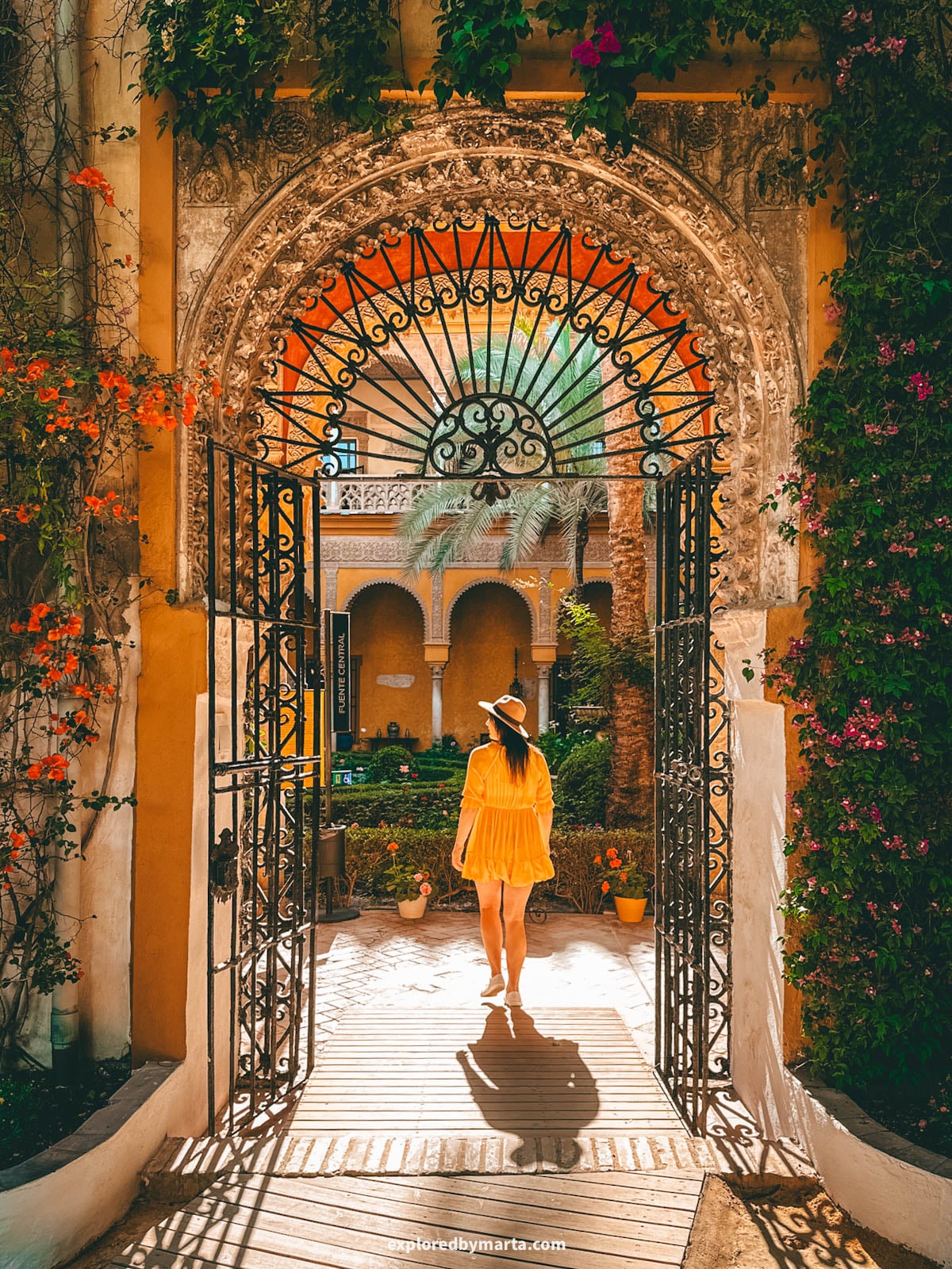 The yellow-arched main patio at Palacio de las Dueñas in Seville, Spain
