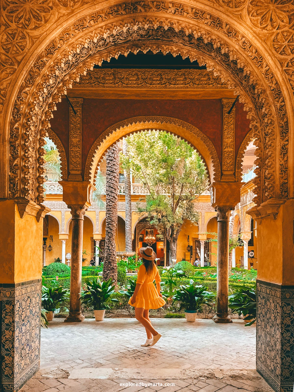 The yellow-arched main patio at Palacio de las Dueñas in Seville, Spain
