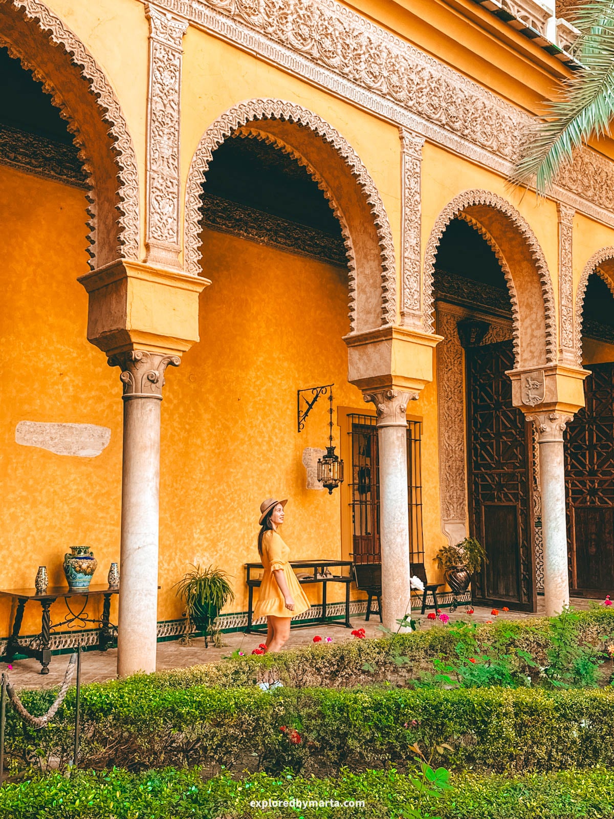 The yellow-arched main patio at Palacio de las Dueñas in Seville, Spain